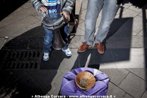 Napoli, 17/02/2012. A children begging  money playing a drum with his father.