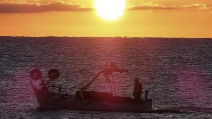 Una alba ad Albenga con vista mare e una barca di pescatori nella foto di Roberto Ruaro