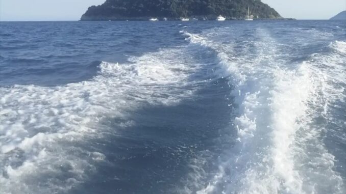 Albenga mare visto dalla barca con scia di onde e Isola Gallinara che si allontana nella foto di Roberto Ruaro