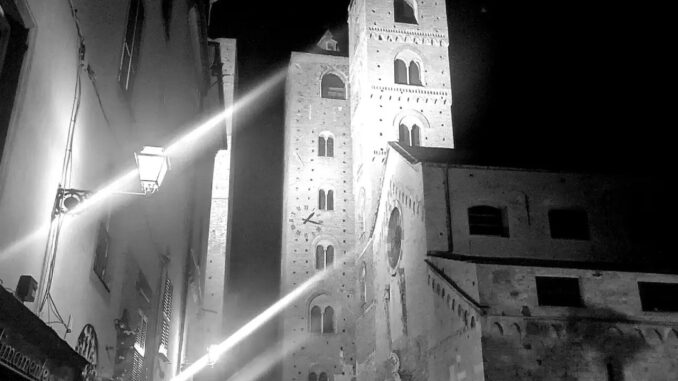 passanti nelle notti sotto le torri del centro storico di Albenga