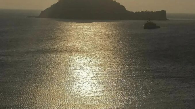 un quieto mar ligure all'albva con la sagooma dell'Isola Gallinara di Albenga