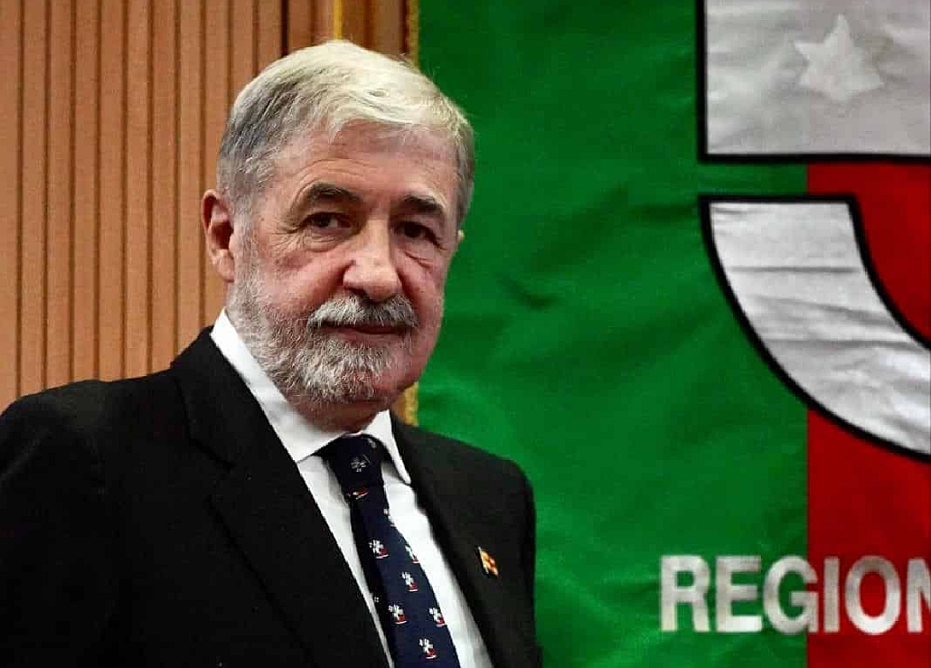 il presidente Marco Bucci vicino allo stendardo istituzionale della Regione Liguria