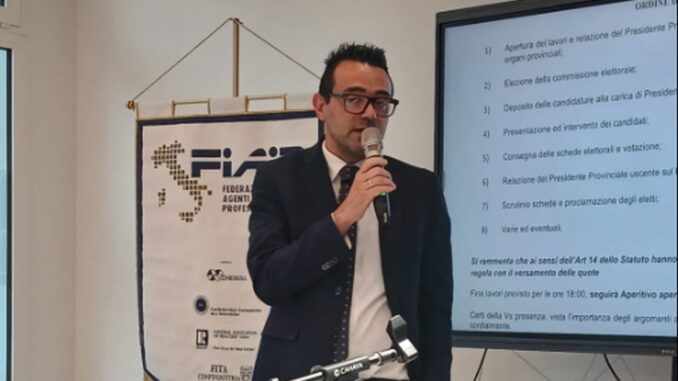 In piedi con il microfono durante un'assemblea dell'associazione Alessio Bellinghieri, delegato regionale al turismo per la Fiaip e presidente provinciale della Fiaip a Imperia