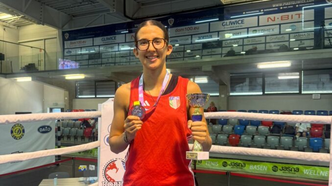 Amelia Zamana sul ring mostra la medaglia e la coppa vinta