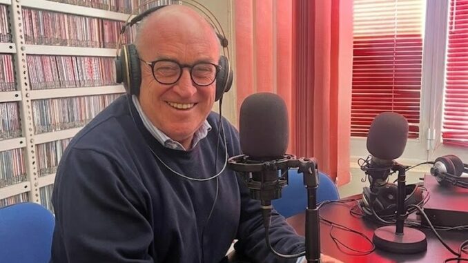 Carlo Scrivano seduto davanti ai microfoni