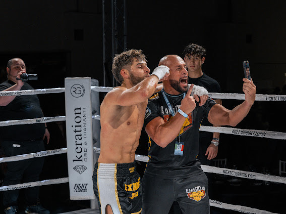 il coach con gli atleti sul ring dopo una vittoria